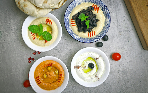 A table with four bowls of hummus and a bowl of olives from Chrome web store to be run with OffiDocs Chromium online A table with four bowls of hummus and a bowl of olives from Chrome web store to be run with OffiDocs Chromium online
