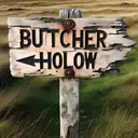 old sign post reading butcher hollow with black arrow pointing